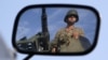 A Turkish soldier is reflected on a mirror as he stands guard on top of an armored personnel carrier on the Turkish-Syrian border near the Akcakale border crossing, October 4, 2012. 