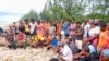 Des enquêteurs échangent avec des habitants sur les rives après un accident de bateau qui a fait des dizaines de morts à Soanierana Ivongo, dans le nord de Madagascar, le 20 décembre 2021. 
