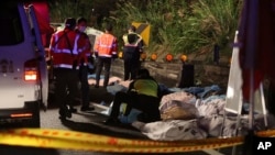 Bodies are covered as emergency services attend the scene of a crash where a bus collided with a car on a highway in Taipei, Taiwan, Feb. 13, 2017. 