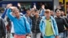 Refugees wave as they arrive at the main train station in Munich, Germany, Saturday, Sept. 5, 2015. Hundreds of refugees arrived in various trains to get first registration as asylum seekers in Germany. 