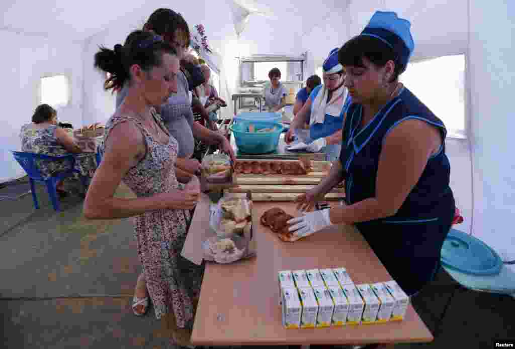 People receive food at a canteen of a refugee camp in Russia's Rostov region, Aug. 18, 2014.