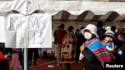 Una mujer con un niño acude a votar en las elecciones regionales de Bolivia el 7 de marzo de 2021.