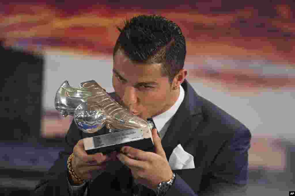 Real Madrid’s striker Cristiano Ronaldo kisses a silver boot award for scoring the most goals for the club during a ceremony at the Santiago Bernabeu stadium in Madrid, Spain. Ronaldo recently overtook Raul Gonzalez to become the club's all-time highest goalscorer with a tally of 324 goals.