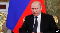 Presiden Rusia, Vladimir Putin, menyimak Presiden Korsel Moon Jae-in dalam sebuah pertemuan di Kremlin, Moskow, Rusia, Jumat, 22 Juni 2018 (foto: Sergei Karpukhin/Pool Photo via AP)