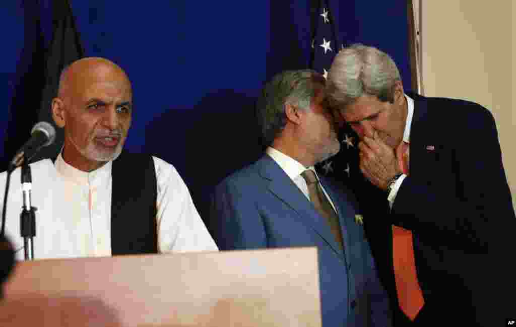 Afghan presidential candidate Ashraf Ghani Ahmadzai (left) speaks while other candidate Abdullah Abdullah (center) talks to U.S. Secretary of State John Kerry during a joint press conference in Kabul, Aug. 8, 2014.