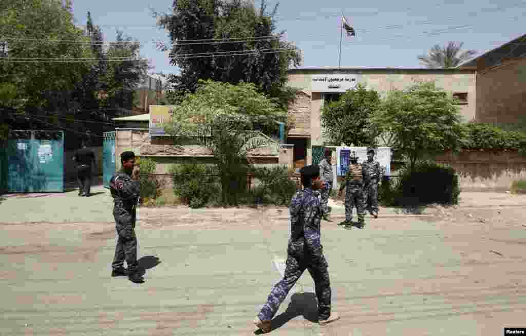 Polisi berjaga di sekitar sebuah TPS di Baghdad, 19 April 2013.