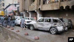 Petugas keamanan meninggalkan lokasi serangan bom di wilayah Karrada, Baghdad, Irak (20/11).