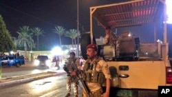 Iraqi security forces stand guard near Bahraini embassy in Baghdad, Iraq, Thursday, June 27, 2019. 