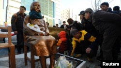 FILE - A statue representing the sexual victims by the Japanese military stands in front of Japanese Consulate in Busan, South Korea, Dec. 30, 2016. A Buddhist monk set himself on fire to protest the agreement with Japan to settle the emotional issue. 