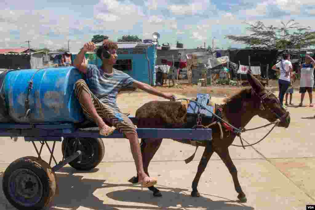 Un joven lleva un tanque de agua en camino al asentamiento La Pista. Se estima que existen 180 cruces informales a lo largo de la frontera, una zona considerada de las más pobres de Colombia y Venezuela.