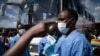Un membre du Centre biomédical du Rwanda prend la température des passagers à un gare routière à Kigali, le 22 mars 2020 ( AFP / Simon Wohlfahrt )