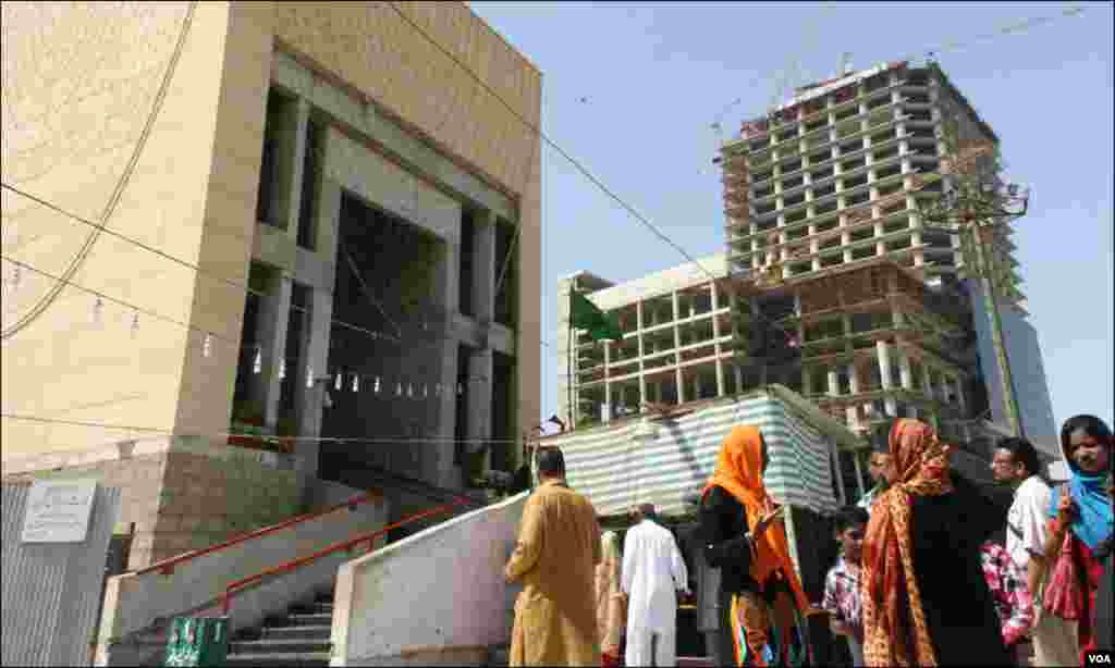 مزار کا نو تعمیر شدہ مرکزی دروازہ اور عقب سے جھانکتا ہوا جدید عمارت کا اسٹرکچر 
