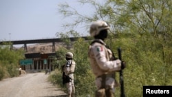 Para petugas Garda Nasional Meksiko berpatroli di perbatasan Meksiko dan AS dalam operasi mencegah para migran menyeberang secarailegal ke wilayah AS, di Ciudad Juarez, Meksiko, 26 Juni 2019.
