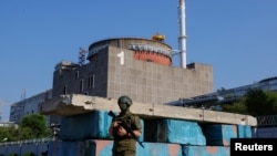 FILE - A Russian service member stands guard at a checkpoint near the Zaporizhzhia Nuclear Power Plant before the arrival of the International Atomic Energy Agency (IAEA) expert mission in the Zaporizhzhia region, Russian-controlled Ukraine, June 15, 2023.
