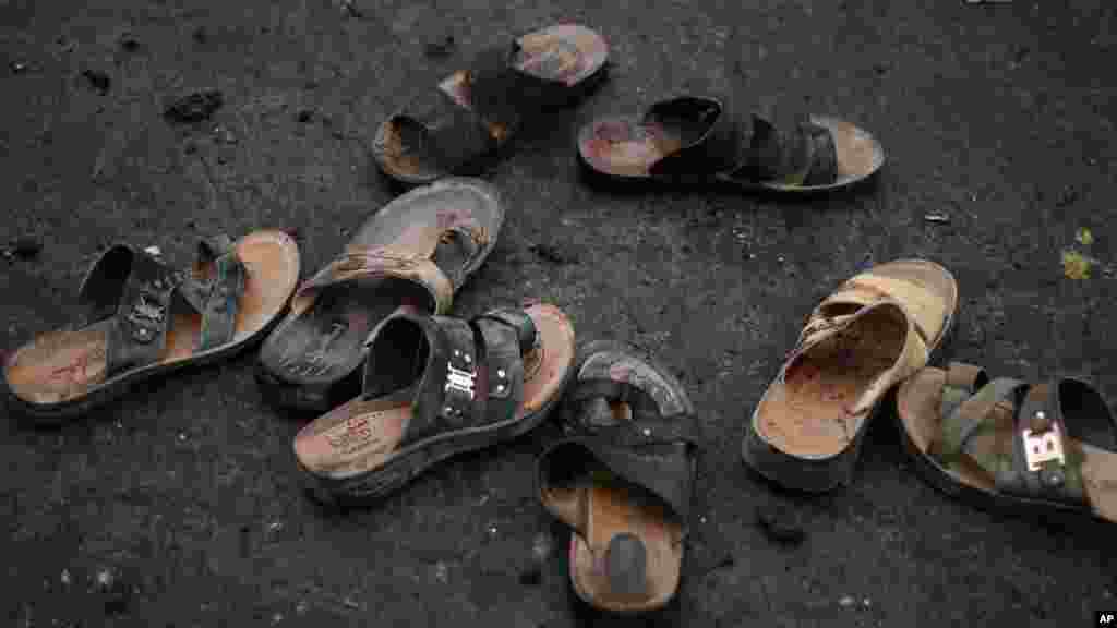 Des sandales avec du sang ont été abandonnées au lieu de l’attaque suicide jeudi le 9 octobre 2014 à Sanaa, Yémen. Les autorités de la sécurité investiguent sur les débris. AP Photo