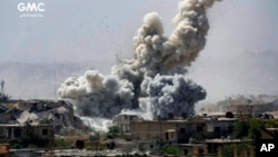 De la fumée et des débris s’élèvent après un bombardement à Damas, Syrie, 25 septembre 2017.
