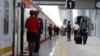 FILE - A man carries an infant as he walks along the platform in front an SGR train traveling to Mombasa from the Nairobi SGR Terminus, outside Nairobi, Kenya, October 22, 2019. 