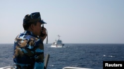 Vietnamese coast guard officer monitors Chinese vessel in the South China Sea, about 210 km (130 miles) off coastal Vietnam, May 15, 2014.
