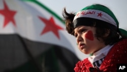 A girl wears a headband in the colors of the Syrian revolutionary flag and painted her face with hearts during a protest in front of the Syrian embassy in Amman, Jordan, May 17, 2013.