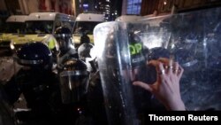 A demonstrator pushes back a police officer during a protest against a newly proposed policing bill, in Bristol, Britain, March 26, 2021.