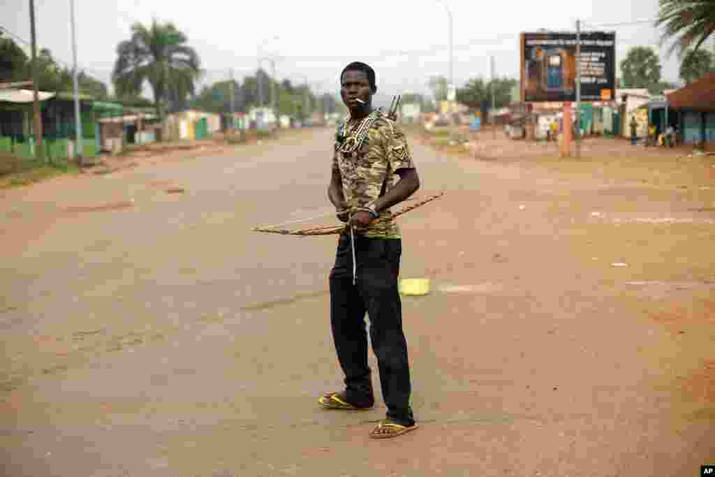 An anti-Balaka Christian militiaman holding a bow and arrow stands in, what days before, was a predominantly Muslim area of the Miskin district of Bangui, Feb. 4, 2014.