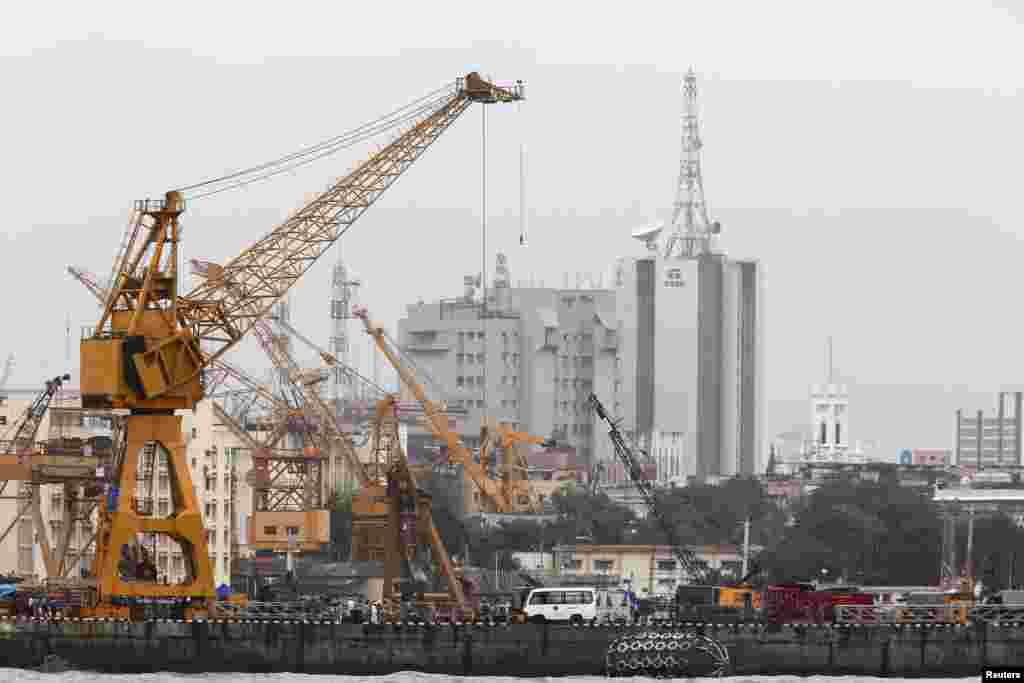 Indian Navy personal and rescue workers stand on a dock at the naval dockyard in Mumbai, August 14, 2013.