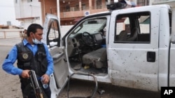 An Iraqi policeman inspects the site of a suicide attack at a polling center in Kirkuk, 290 kilometers (180 miles) north of Baghdad, April 28, 2014.