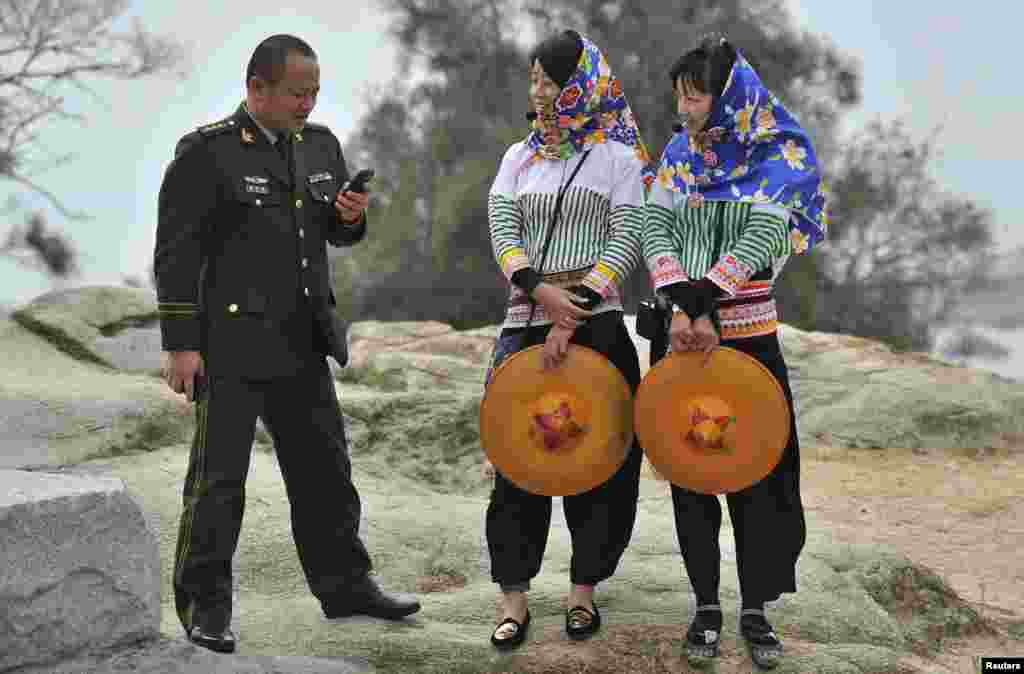 Seorang perwira militer China berbicara dengan dua pemandu wisata suku Hui'an di kota Hui'an, provinsi Fujian, China.