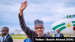 Le président nigérian Muhammadu Buhari salue à descente d’avion, de retour des vacances du Royaume-Uni, à Abuja, Nigeria, 18 août 2018. (Twitter/Bashir Ahmad)
