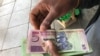 A man in Harare holds bondnotes issued by Reserve Bank of Zimbabwe, Oct. 15, 2018. The introduction of bond notes - a currency Zimbabwe started printing two years ago to ease the situation -- has not helped. (C.Mavhunga/VOA)