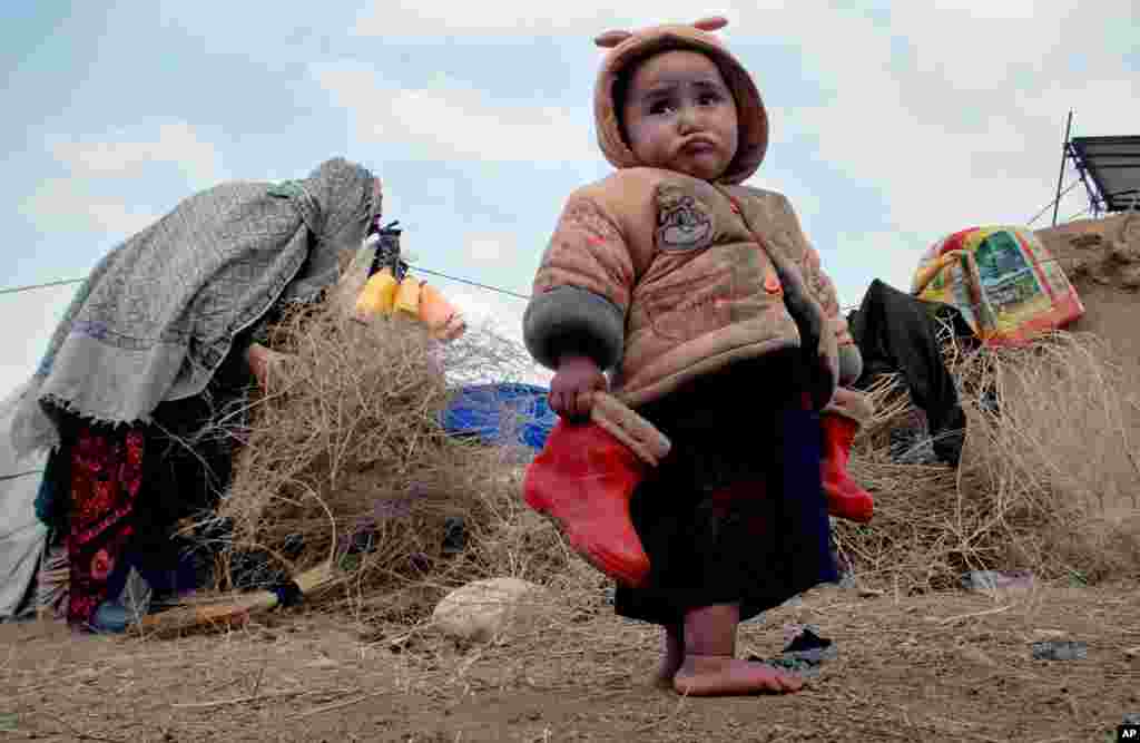 An Afghan child holds his boots in a camp for the internally displaced on the outskirts of Mazar-e Sharif, north of Kabul.