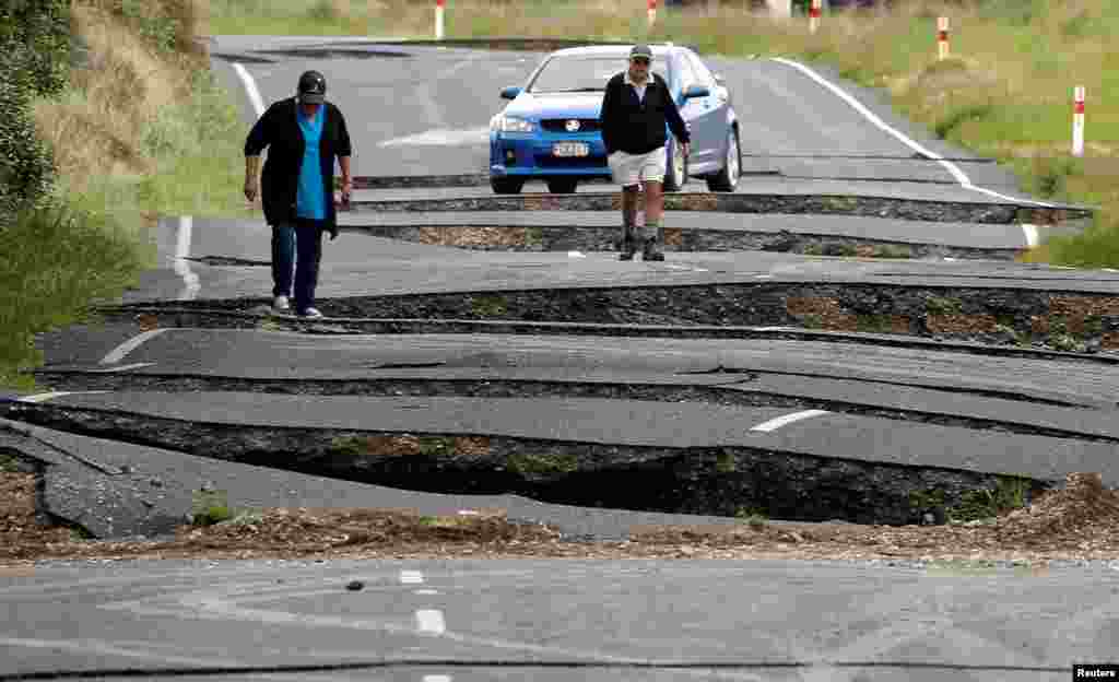 Warga setempat memeriksa jalanan yang rusak akibat gempa di selatan kota Blenheim, Selandia Baru.