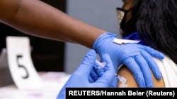 Seorang perempuan menerima vaksin COVID-19 di sebuah klinik di Philadelphia, Pennsylvania, AS, 18 Mei 2021. (Foto: REUTERS/Hannah Beier)
