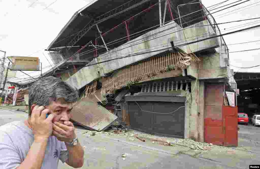Seorang warga berjalan melewati sebuah gedung yang runtuh setelah gempa 7,2 Richter melanda kota Cebu di Filipina tengah.