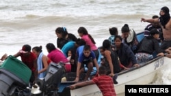 Venezuelan migrants, who were recently deported, arrive at shore on Los Iros Beach after their return to the island, in Erin, Trinidad and Tobago, Nov. 24, 2020. (Lincoln Holder/Courtesy Newsday/Handout via Reuters)