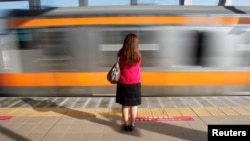A woman waits to board a passenger train car for women only in Tokyo October 2011. The East Japan Railway company and other railway companies, introduced the 'women only' train cars in 2002 as part of efforts to deal with the problem men who sexually harass female passengers. REUTERS/Yuriko Nakao