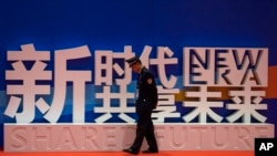 一名保安在上海中国国际进口博览会的口号前走过。（2018年11月5日）