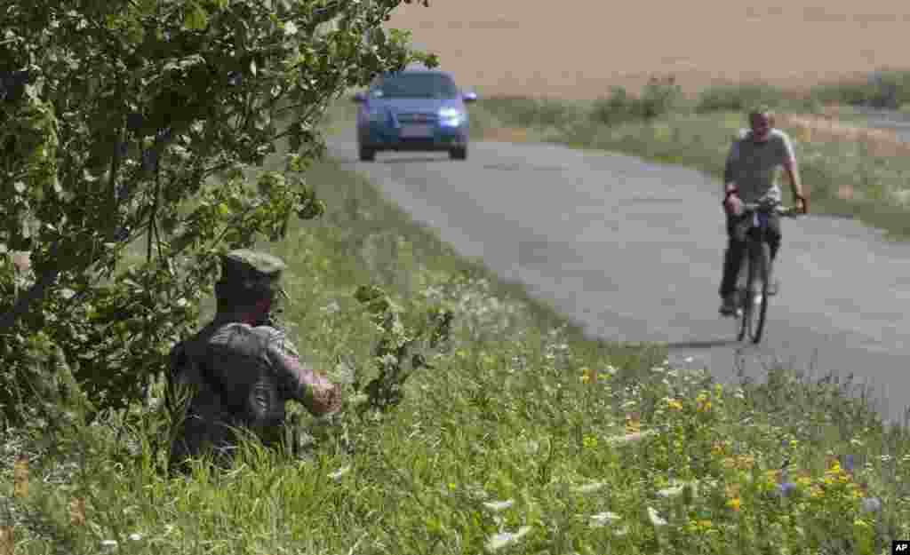 Australian investigators examine the area of the Malaysia Airlines plane crash in the village of Hrabove, Donetsk region, eastern Ukraine, Aug. 1, 2014. 