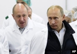Pengusaha Yevgeny Prigozhin, kiri, menunjukkan Presiden Rusia Vladimir Putin, di sekitar pabriknya di luar St. Petersburg, Rusia. (Foto: via AP)