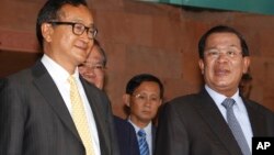 Cambodian Prime Minister Hun Sen, right, talks with the main Opposition Party leader Sam Rainsy, left, of Cambodia National Rescue Party, after their meeting in Senate headquarters in Phnom Penh, Cambodia, July 22, 2012.