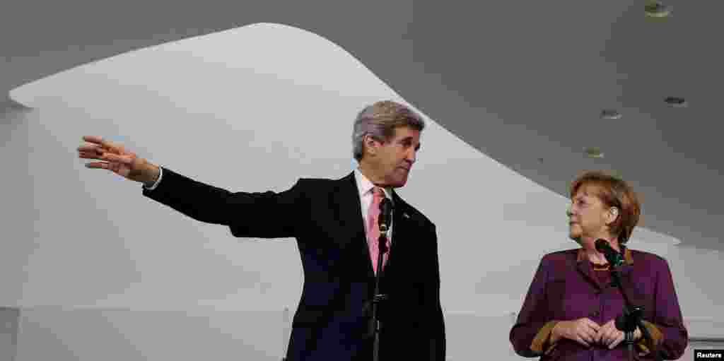 U.S. Secretary of State John Kerry and German Chancellor Angela Merkel speak to the media at the Chancellery in Berlin, Feb. 26, 2013.