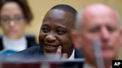 Presiden Kenya Uhuru Kenyatta tersenyum, duduk di antara pengacaranya dalam persidangan di ICC, Den Haag, Belanda, 8/10/2014. ICC akhirnya membatalkan tuduhan atas Presiden Kenya itu. 