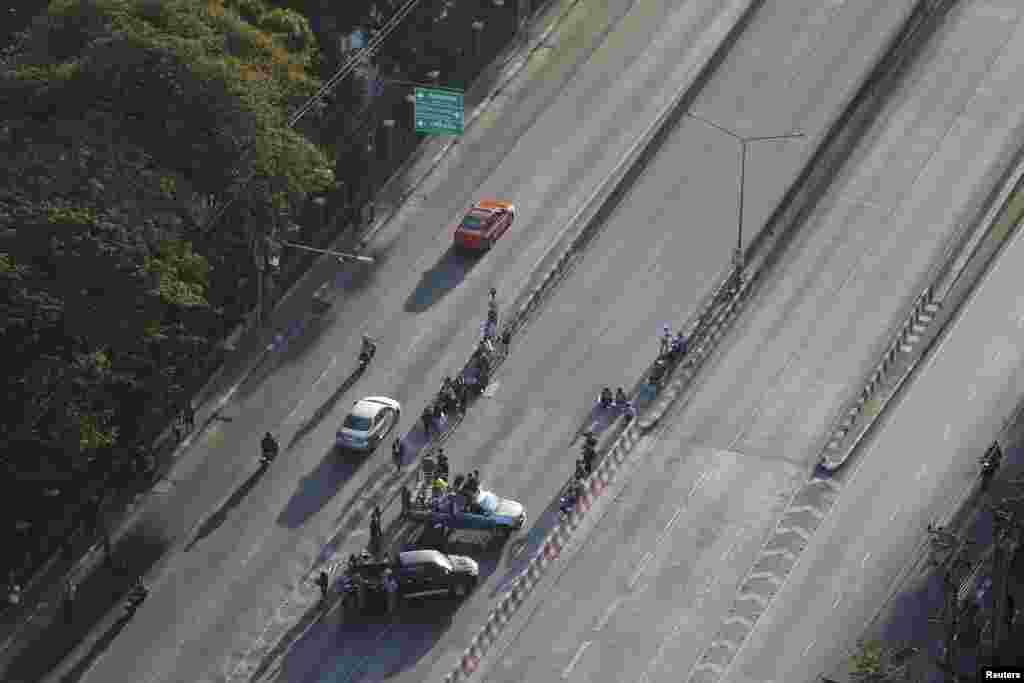 Para pengunjuk rasa memblokir jalan persimpangan jalan besar di pusat kota Bangkok (13/1).