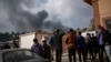 Warga Palestina melihat ke arah kepulan asap pasca serangan udara Israel di kota Khan Younis, Jalur Gaza selatan. 