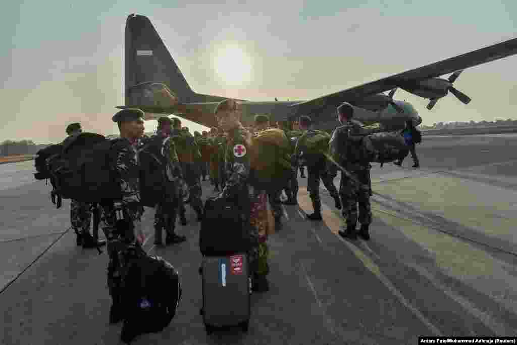Indonesian soldiers walk to a Hercules military plane heading to Palu at Halim Perdanakusuma military base in Jakarta, Indonesia, Sept. 29, 2018.