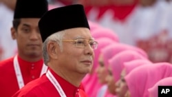 FILE - President of the ruling United Malays National Organisation (UMNO) and Malaysia's Prime Minister Najib Razak inspects a ceremonial guard of honor.
