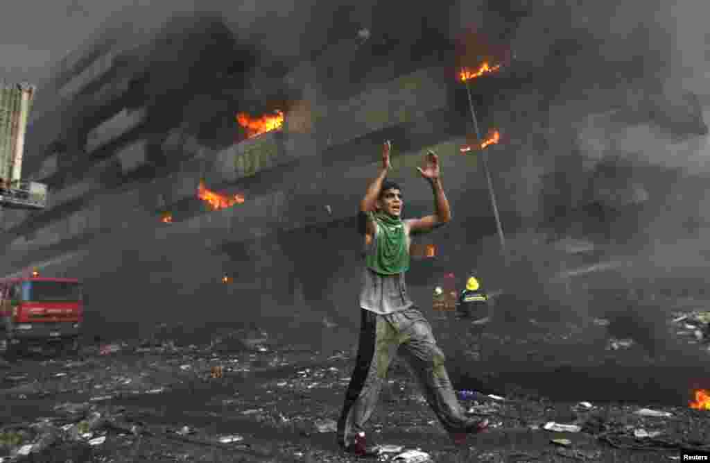 A man runs down a street warning people to flee shortly after a twin car bomb attack at Shorja market in Baghdad, Feb. 12, 2007.