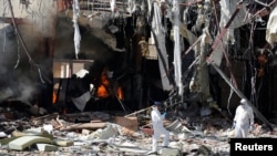 Forensic experts investigate the scene at the community hall where Saudi-led warplanes struck a funeral in Sanaa, the capital of Yemen, October 9, 2016. 