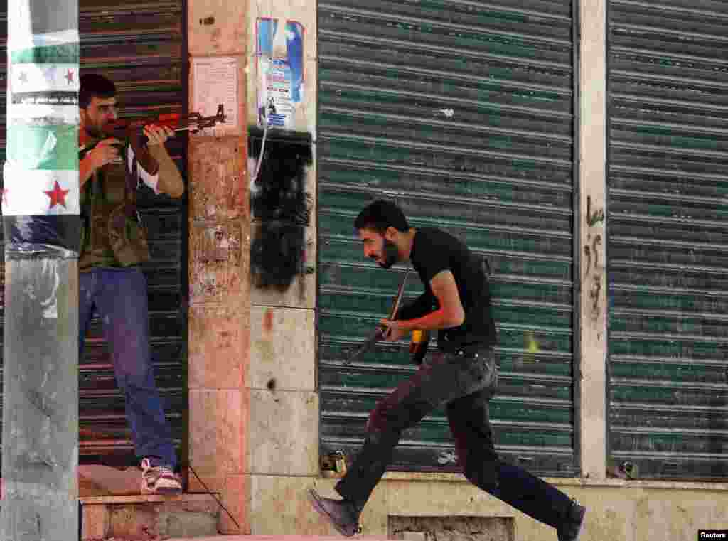 Free Syrian Army fighter runs for cover during clashes with Syrian Army soldiers in the Salah al- Din neighborhood of central Aleppo August 5, 2012.