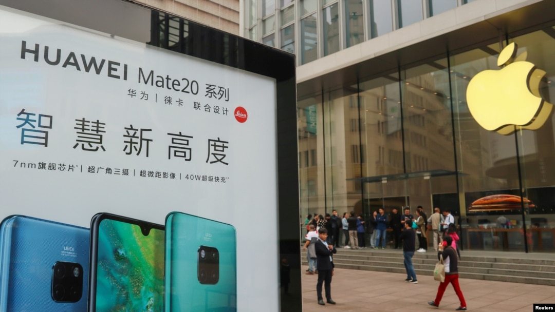 2018年10月26日在中國上海的Apple商店外面，顧客排隊購買新的iPhone XR手機，附近有華為Mate 20系列產品的廣告。